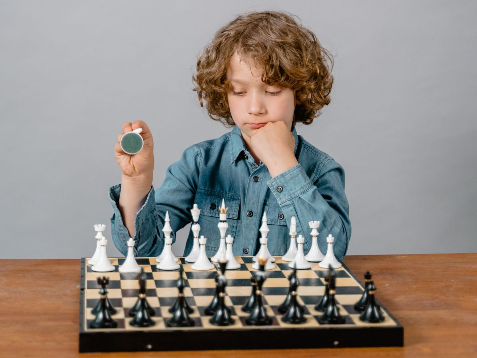 A thoughtful young boy playing chess, showcasing strategic thinking and focus.